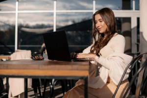 Small business owner working calmly on a laptop at a sunny café