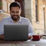 A small business owner working confidently on a laptop, reviewing his website