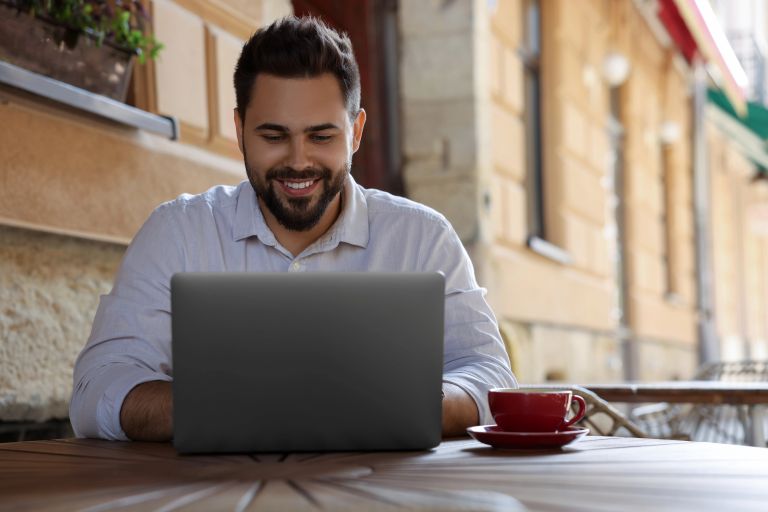 A small business owner working confidently on a laptop, reviewing his website